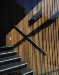 Shadows cutting across a brightly lit set of stairs causing diagonal intersections.
