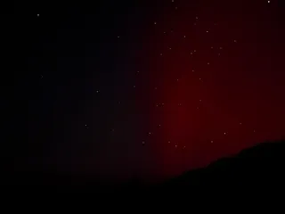 The right half of the night sky with a vertical red beam